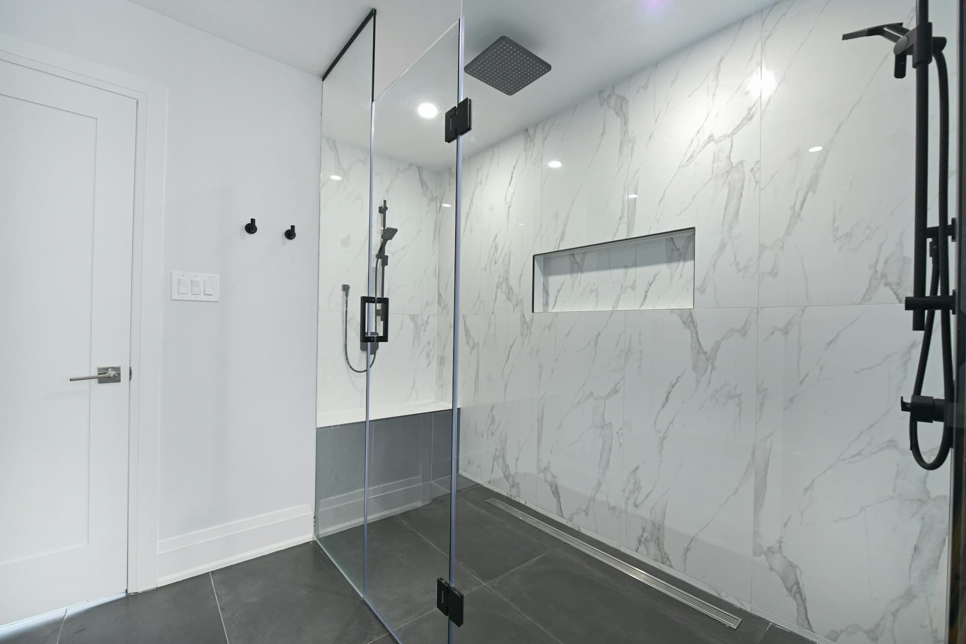 Açık mermer duvarlı, cam duşakabinli modern banyo
